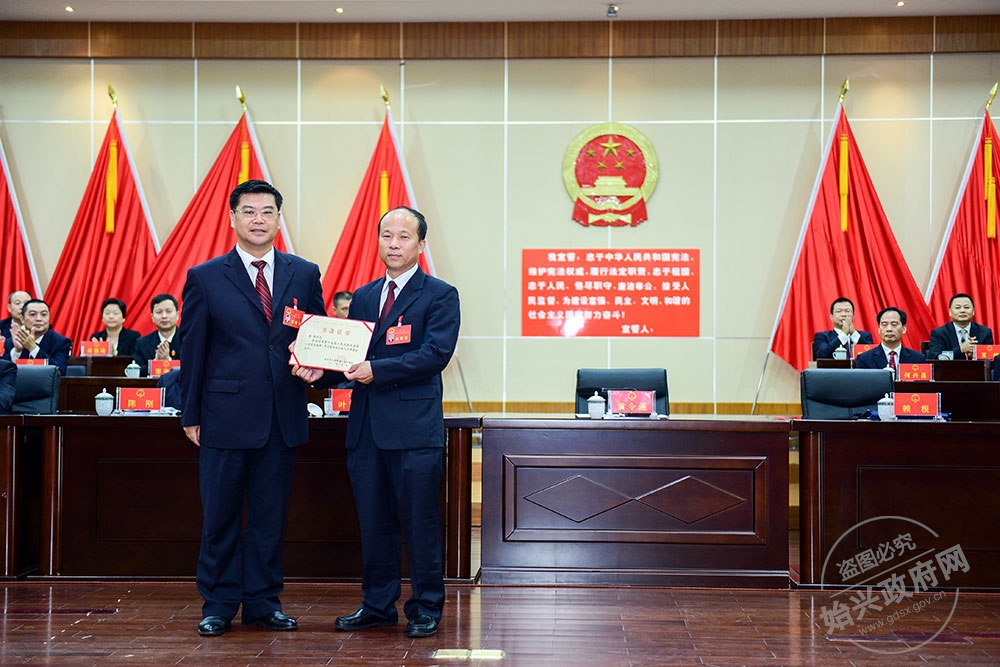 賴根當選縣人大常委會主任，圖為縣委書記黃令遙為賴根（右）頒發當選證書