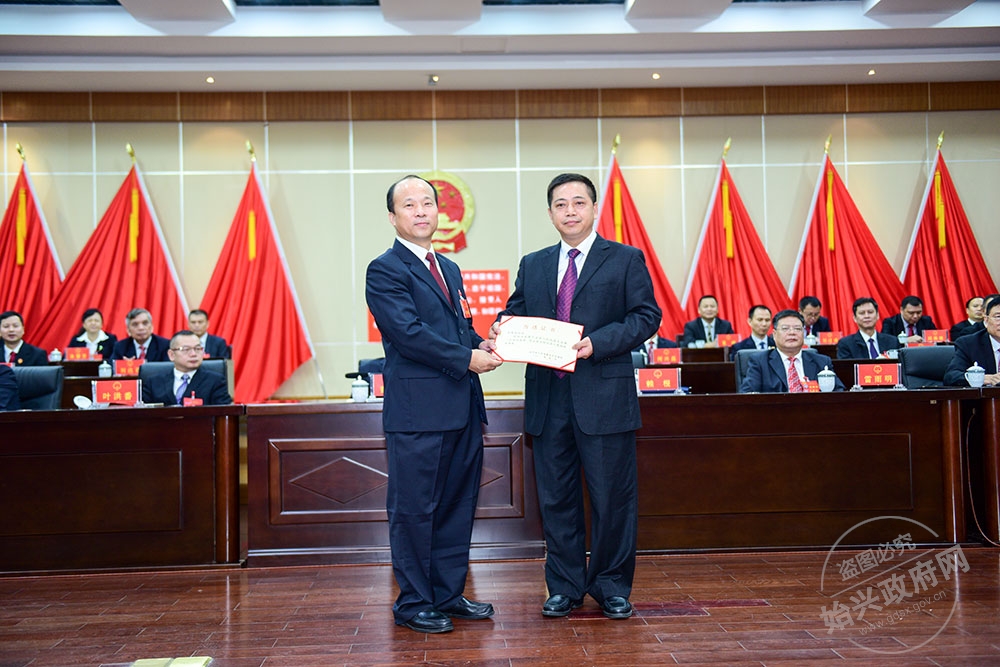 張智光當選為始興縣人民政府副縣長，，圖為賴根為張智光（右）頒發當選證書