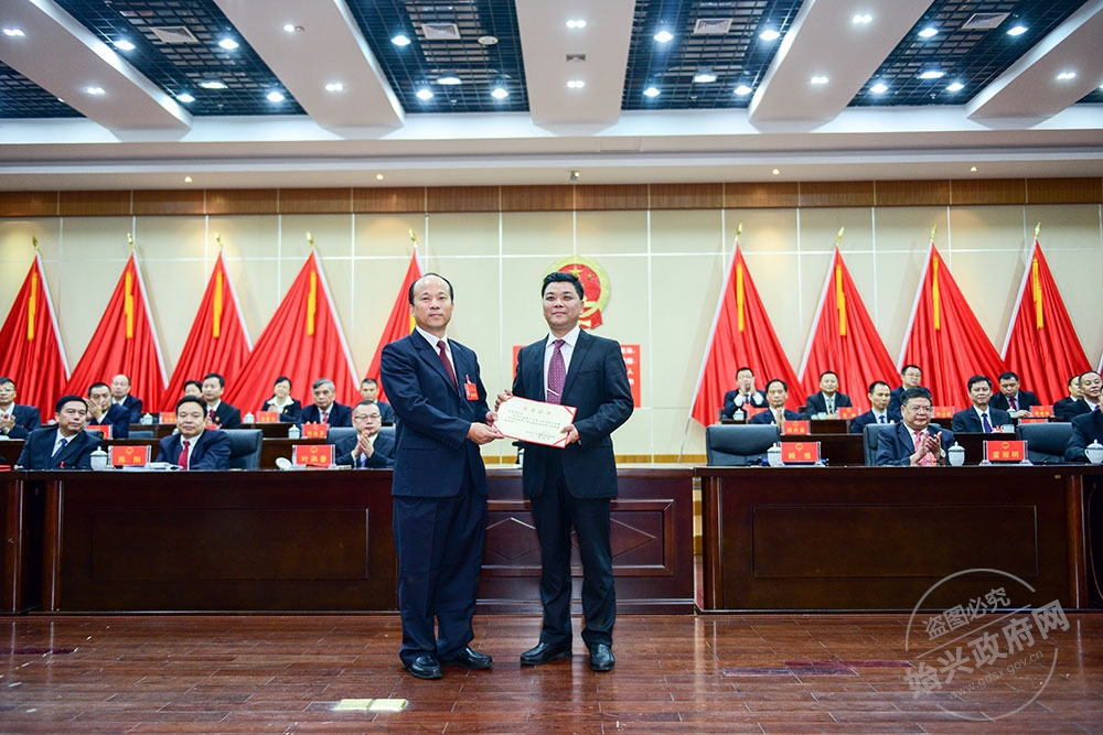 何武強當選為始興縣人民政府副縣長，，圖為賴根為何武強（右）頒發當選證書